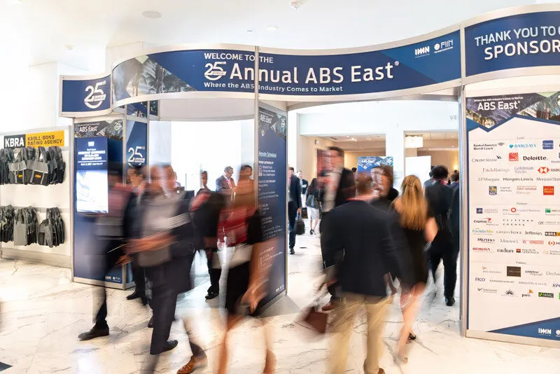 Attendees moving through the entrance of a large industry conference
