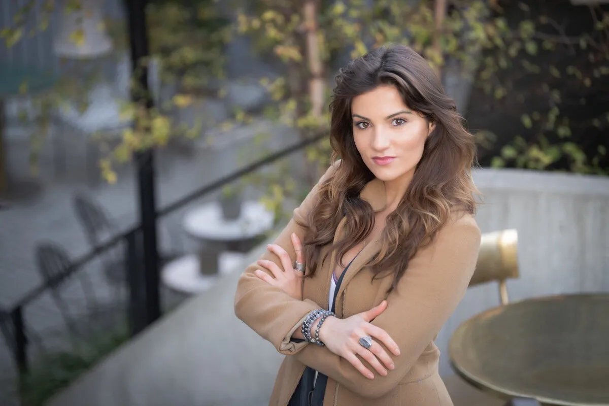 Portrait of a woman with arms crossed on a rooftop terrace
